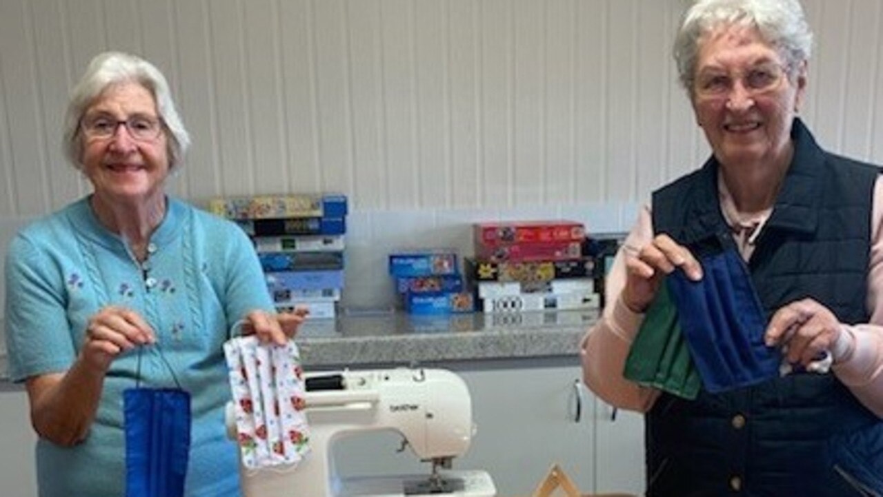STITCHING FOR SAFETY: Carlyle Gardens residents Judy Wilkie and Fae Ash with some of the masks made by the Sewing Circle.