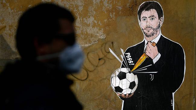 A man walks past a graffiti entitled 