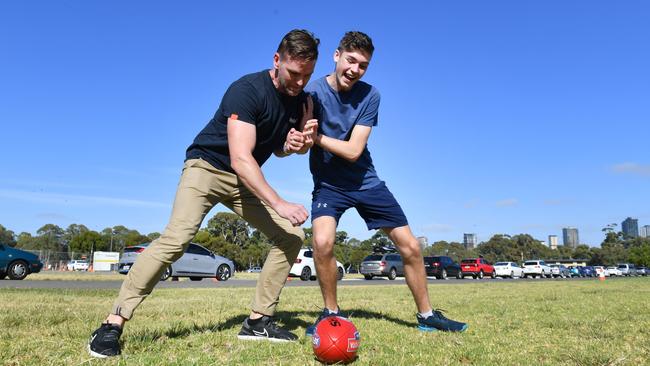 Nigel and Isaac Brooks play football while waiting for a test at Victoria Park. Picture: Keryn Stevens