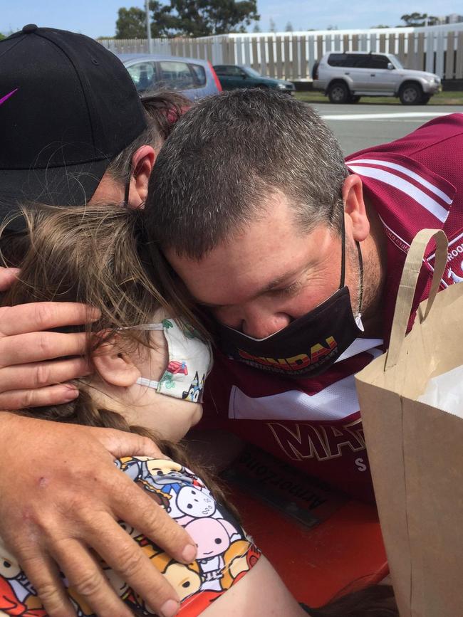 Bonnie, 8, embraces parents Boyd and Kathy McNamara across the border.