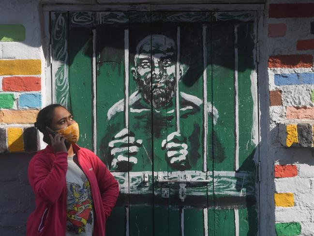 A woman seaks next to a mural depicting the coronavirus lockdown in Kolkata, India, on Saturday. Picture: AFP