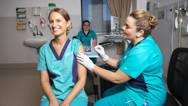 Registered Nurse Zoe Park receives the first COVID-19 vaccine from clinical nurse consultant Kellie Kenway at Gold Coast University Hospital. Picture: Nigel Hallett-Pool