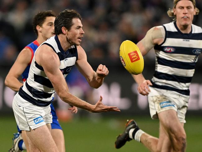 Isaac Smith dishes out a handball. Picture: Morgan Hancock/AFL Photos/via Getty Images