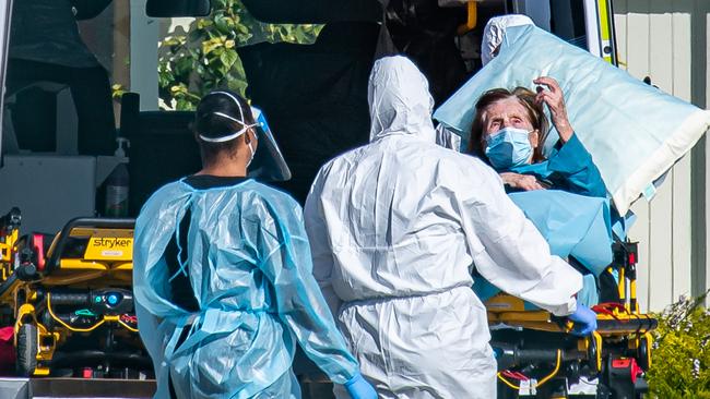 An elderly woman gestures to paramedics. Picture: Jason Edwards