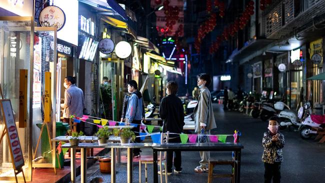 People wearing facemasks order take out food in Huanggang, in China’s central Hubei province. Picture: Noel Celis / AFP.