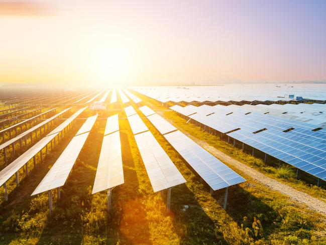 Photovoltaic modules reflect sunset light and clouds