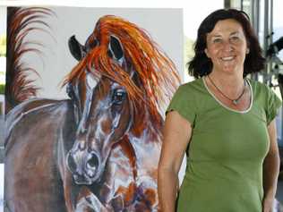 Marina Izatt stands next to Big Red by Jill Vanstone, which will be on display at Bunyip Scenic Rim Resort as part of an art show by local artisans. . Picture: Claudia Baxter