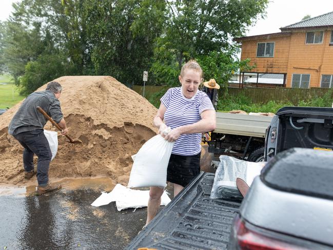 Scott and Kate Dunn of Ballina fill sandbags at the Lismore Workers Golf Club after Ballina sandbag filling sites ran out of supplies, leading to large queues waiting for the delivery of new materials. Picture: David Freund