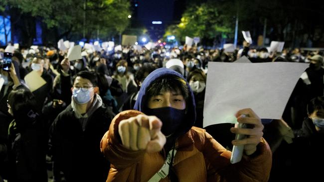 People hold white sheets of paper in protest over coronavirus disease (COVID-19) restrictions, after a vigil for the victims of a fire in Urumqi in November.