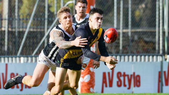 Glenelg's Brad Close is tackled by Port’s Hamish Hartlett. Picture: AAP/Brenton Edwards