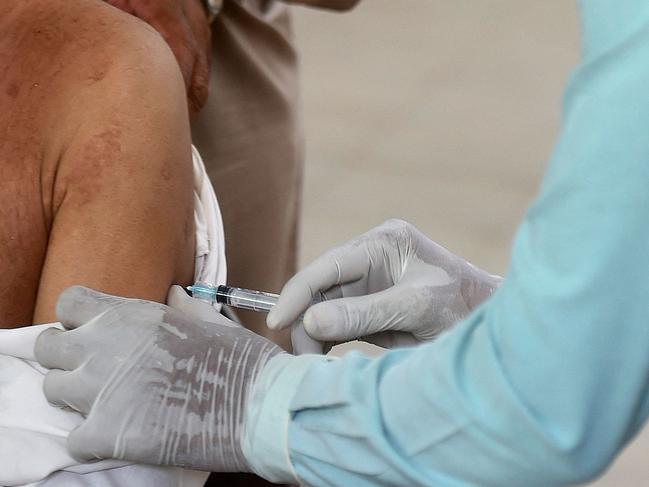 A health worker inoculates a man with a dose of AstraZeneca. Picture: AFP.