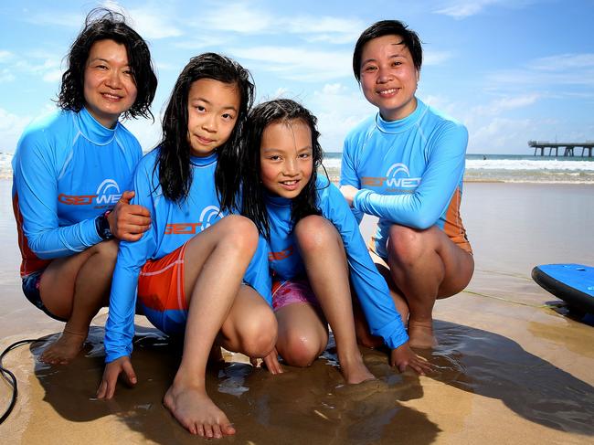 Chinese tourists including Fu Min Yi, her daughter Cai Queen, 9, Zhou Zi Yan, 7, and her mum Zhou Hai Ying, enjoy learn-to-surf classes at the Spit on the Gold Coast with Get Wet Surf School. Picture: Adam Head