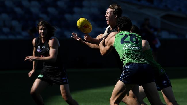 Tyler Brown gets a handball off under pressure during a joint AFL training session at GMHBA Stadium. Picture: James Ross/AAP