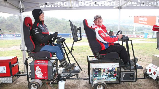 Michelle Branch and Brad Denning find time to race against each other on driving simulators attached to his mobile Esky. Picture: Richard Dobson