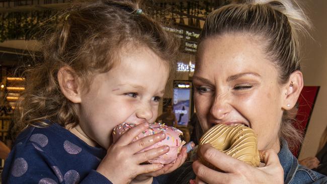 Three year old Summer Simon tries out the doughnuts at Brooklyn Donuts with her mother Roxy Simon. Friday, August 20, 2021. Picture: Nev Madsen.