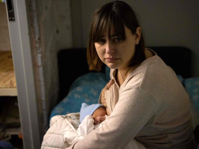 A mother nurses her child as she reacts after a residential building was hit by debris from a downed rocket in Kyiv on March 20, 2022. Picture: Fadel Senna, AFP