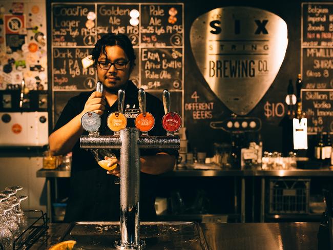 Chris Benson pulls a beer at Six String Brewery.