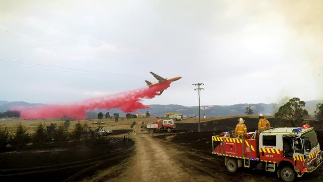 Volunteers from the Mittagong Rural Fire Service watch on as a DC-10 air tanker drops retardant to save homes on a rural property near Taralga, Pic: Charlton Durie / Mittagong Rural Fire Brigade.