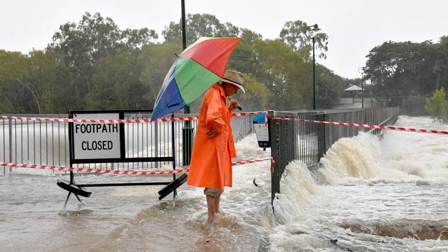 Ian McCubben checks the water flow at Aplins Weir as heavy rain lashes Townsville. Picture: Evan Morgan