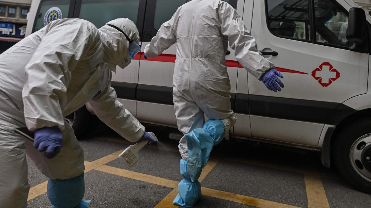 Medical staff spraying disinfectant on his colleague after arriving at Wuhan Red Cross Hospital with an elderly woman, who recovered from COVID-19. Picture: Hector Retamal/AFP