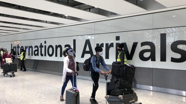 Passengers are escorted through the arrivals area of terminal 5 towards coaches destined for quarantine hotels, after landing at Heathrow airport.