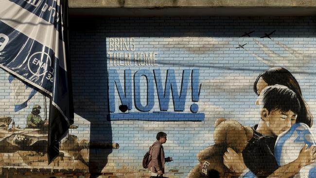 A man passes by a wall graffiti calling for the return of hostages that were kidnaped during the Oct 7 Hamas. Picture: Photo by Amir Levy/Getty Images