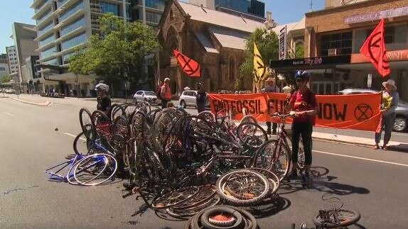 Extinction Rebellion activists close Flinders St outside Santos, protesting it as the Tour Down Under sponsor. Picture: 9 News