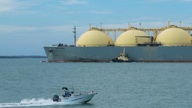 An amateur fisher passing an LNG ship in Darwin Harbour. Picture: Glenn Campbell