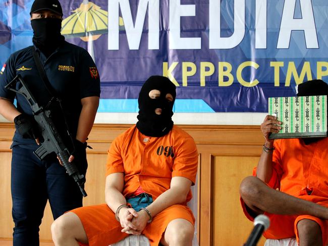 The 35-year-old was paraded in media conference today in Bali, wearing a black balaclava over his head and bright orange prisoner shorts and shirt. Picture: Lukman Bintoro