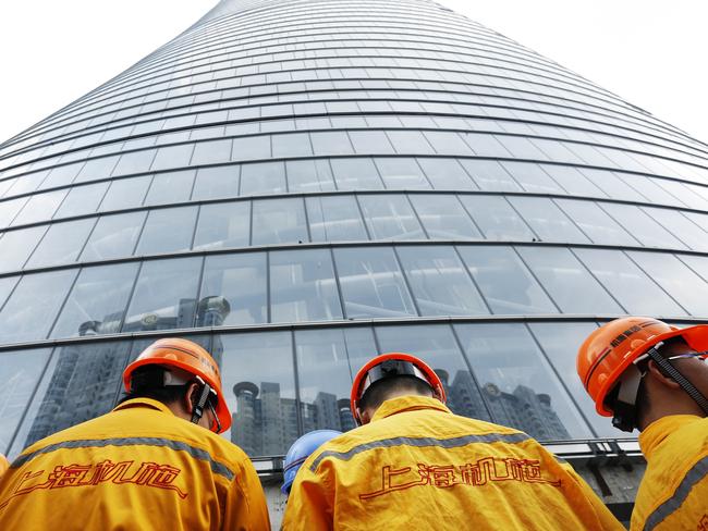 SHANGHAI, CHINA - AUGUST 03: (CHINA OUT) Construction workers prepare to install the final steel beam on the 632-meter-high Shanghai's tallest building on August 3, 2014 in Shanghai, China. The final steel beam has now been installed on Shanghai's tallest building, the world's second tallest. (Photo by ChinaFotoPress/ChinaFotoPress via Getty Images)