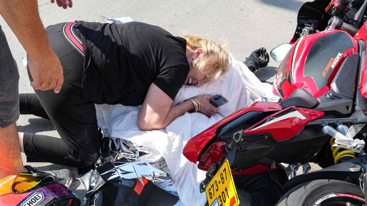 A woman weeps over the covered corpse of her nephew who was shot dead in the southern city of Sderot. Picture: AFP