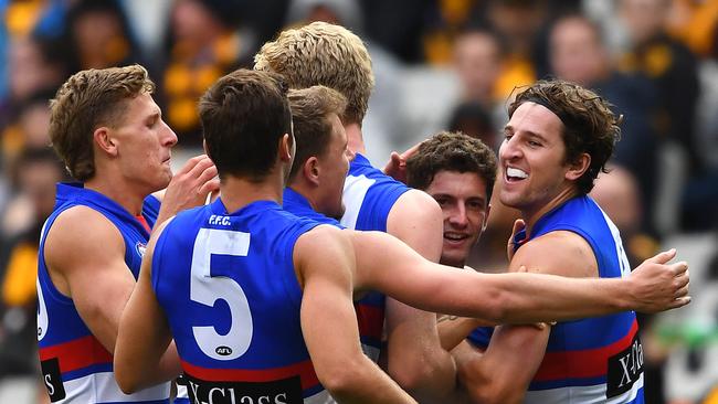 MELBOURNE, AUSTRALIA - MARCH 31: Tom Liberatore of the Bulldogs is congratulated by team mates after kicking a goal during the round two AFL match between the Hawthorn hawks and the Western Bulldogs at Melbourne Cricket Ground on March 31, 2019 in Melbourne, Australia. (Photo by Quinn Rooney/Getty Images)