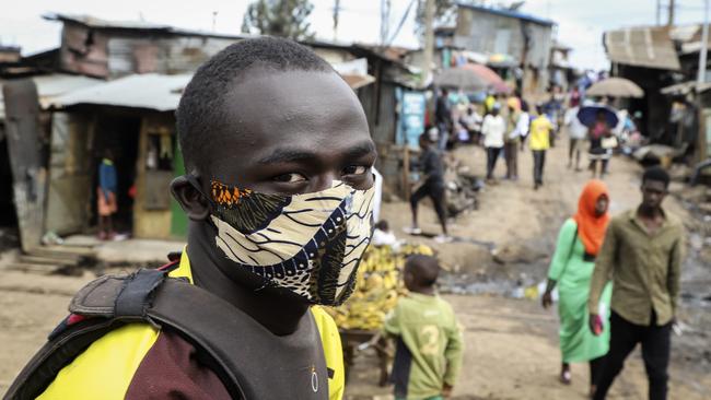 A motorcycle taxi driver in a makeshift mask looks for customers in the Kibera neighborhood of Nairobi, Kenya.