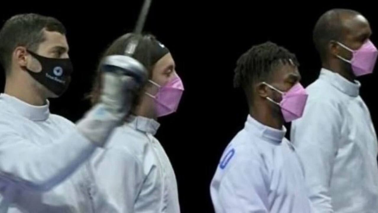 Three American fencers wear pink masks as Alen Hadzic stands next to them.