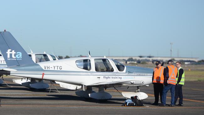 Australian Transport Safety Bureau officers inspect the wing of a Flight Training Adelaide Socata TB-10 aircraft at Parafield Airport in July, after what was later reported to be a bat strike.