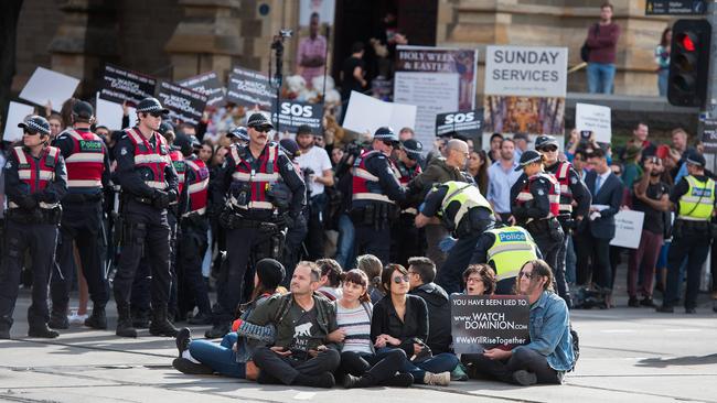 Police move in on animal rights protesters who had blocked the intersections of Flinders and Swanston Street, in Melbourne, Monday, April 8, 2019. Animal rights protesters are slowly being arrested and dragged into police vans after blocking a major Melbourne CBD intersection. (AAP Image/Ellen Smith) NO ARCHIVING