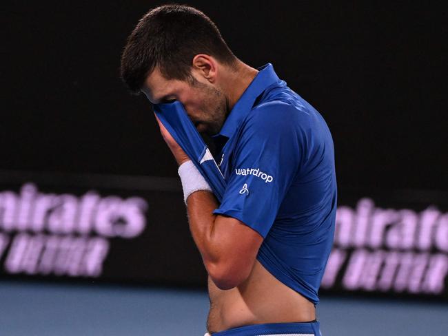 Serbia's Novak Djokovic wipes his face after a point against Croatia's Dino Prizmic during their men's singles match on day one of the Australian Open tennis tournament in Melbourne on January 14, 2024. (Photo by WILLIAM WEST / AFP) / -- IMAGE RESTRICTED TO EDITORIAL USE - STRICTLY NO COMMERCIAL USE --