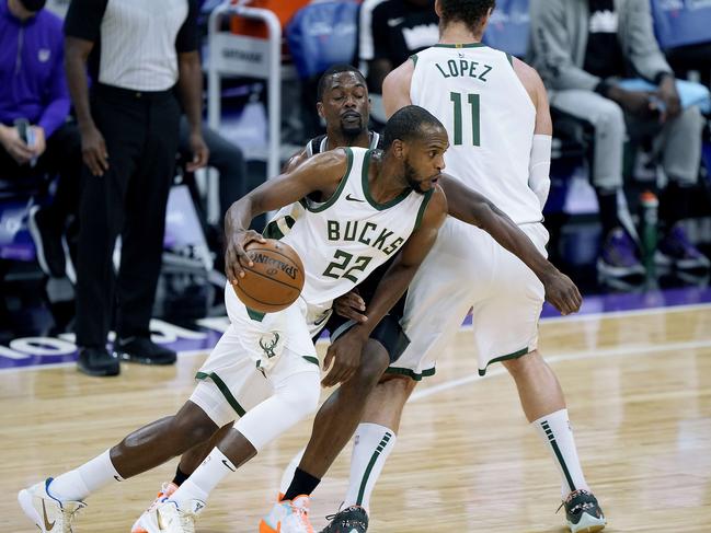 SACRAMENTO, CALIFORNIA - APRIL 03: Khris Middleton #22 of the Milwaukee Bucks dribbles around a screen set by Brook Lopez #11 on Harrison Barnes #40 of the Sacramento Kings during the first half of an NBA basketball game at Golden 1 Center on April 03, 2021 in Sacramento, California. NOTE TO USER: User expressly acknowledges and agrees that, by downloading and or using this photograph, User is consenting to the terms and conditions of the Getty Images License Agreement.   Thearon W. Henderson/Getty Images/AFP == FOR NEWSPAPERS, INTERNET, TELCOS & TELEVISION USE ONLY ==