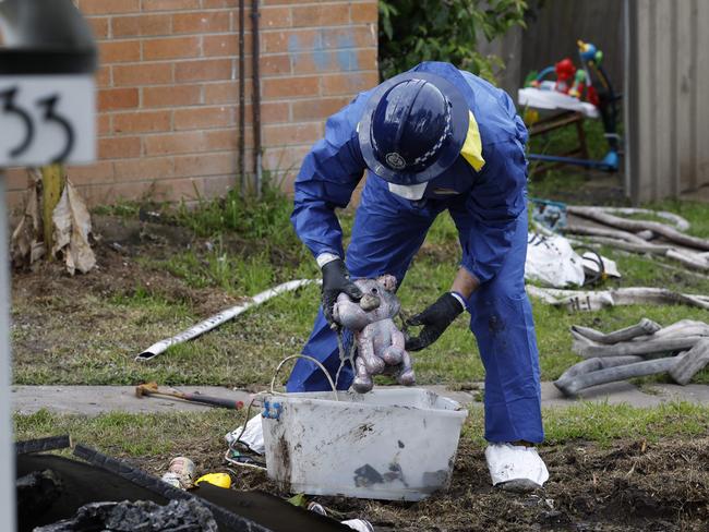 A forensics police officer at the scene of the horrific house fire in Lalor Park. Picture: Richard Dobson