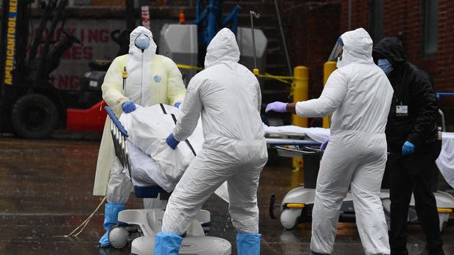 Medical personnel move a deceased patient to a refrigerated truck serving as make shift morgues at Brooklyn Hospital Center.