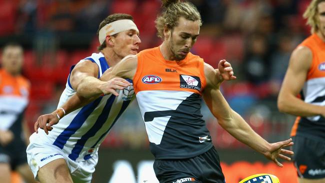 Matt Buntine kicks as he is tackled by Drew Petrie.