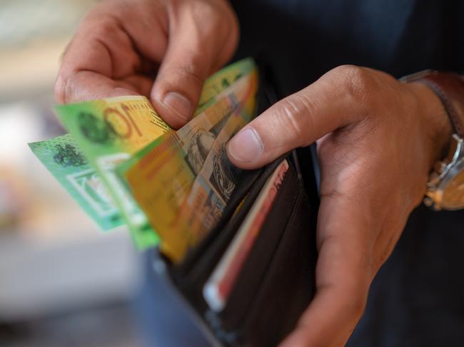 a male taking money out of a wallet, Australian cash generic spending