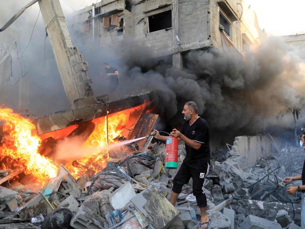 A Palestinian man uses a fire extinguisher to douse a fire following an Israeli strike, in Khan Yunis in the southern Gaza Strip. picture” AFP