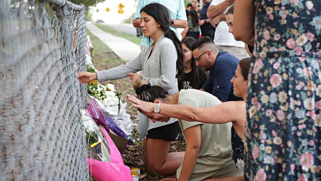 Mother Leila Geagea touches rosary beads at the site where three of her children were killed. Picture: Adam Yip