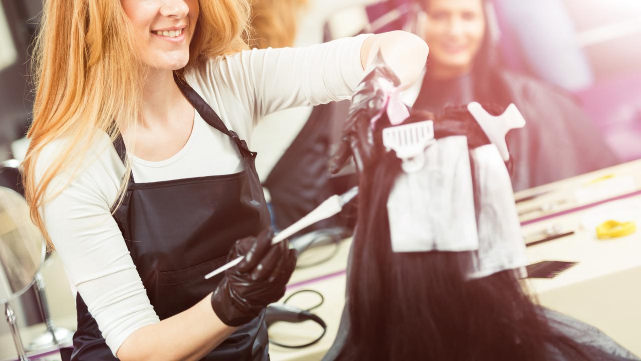 Portrait of woman professional hairdresser during hair dye process