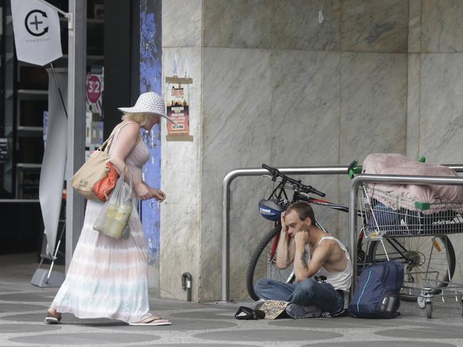 A woman stops in St Kilda to assist Marcus Hemi. Picture: Valeriu Campan