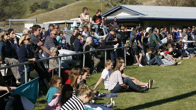 A big crowd including fans on the back of a ute watches the 2011 Omeo and District league grand final at Ensay in 2011.