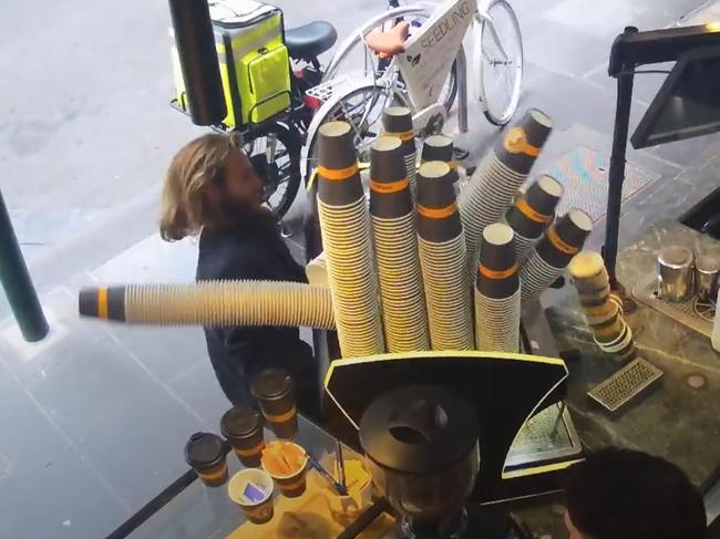 A man tries to take a coffee machine from a business on Elizabeth St in April. Picture: Supplied