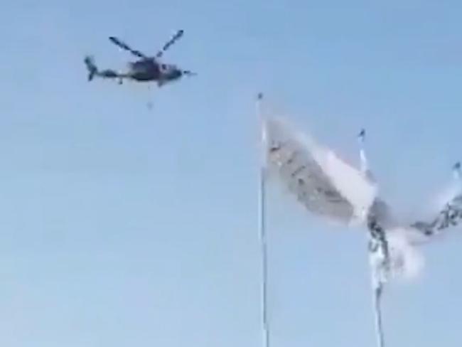 A Black Hawk purportedly flown by the Taliban with what appears to be a body hanging below it.