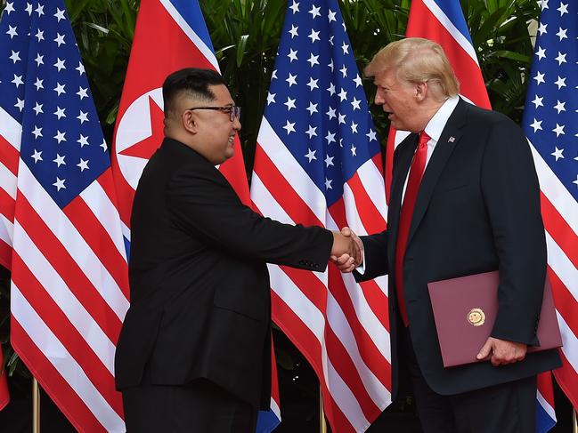 North Korea's leader Kim Jong Un (L) shakes hands with US President Donald Trump (R) after taking part in a signing ceremony at the end of their historic US-North Korea summit, at the Capella Hotel on Sentosa island in Singapore on June 12, 2018. Donald Trump and Kim Jong Un became on June 12 the first sitting US and North Korean leaders to meet, shake hands and negotiate to end a decades-old nuclear stand-off. / AFP PHOTO / POOL / Anthony WALLACE